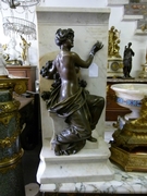 A  patinated bronze sculpture of a lady mounted on a marble base by Marcel Debut.