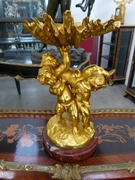A bronze gilded centerpiece with 3 putto,s on a griot base.