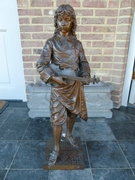 A bronze sculpture of a young boy with a guitar by Bouret.